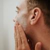 applying cream to mans face